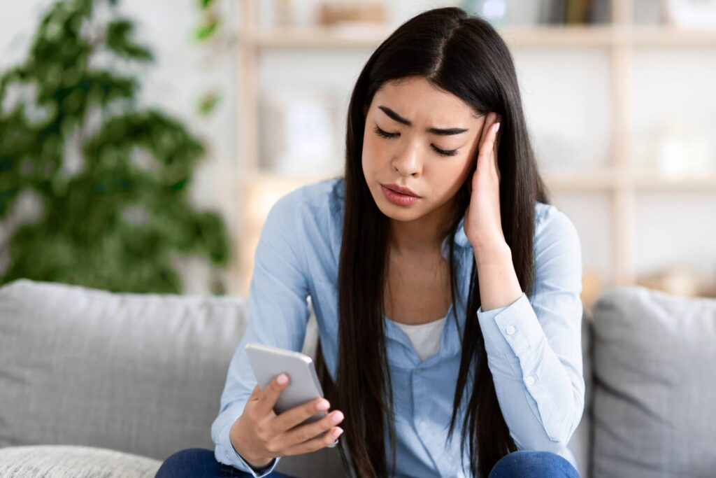 Woman worried on her phone wondering how to work with a codependent partner.